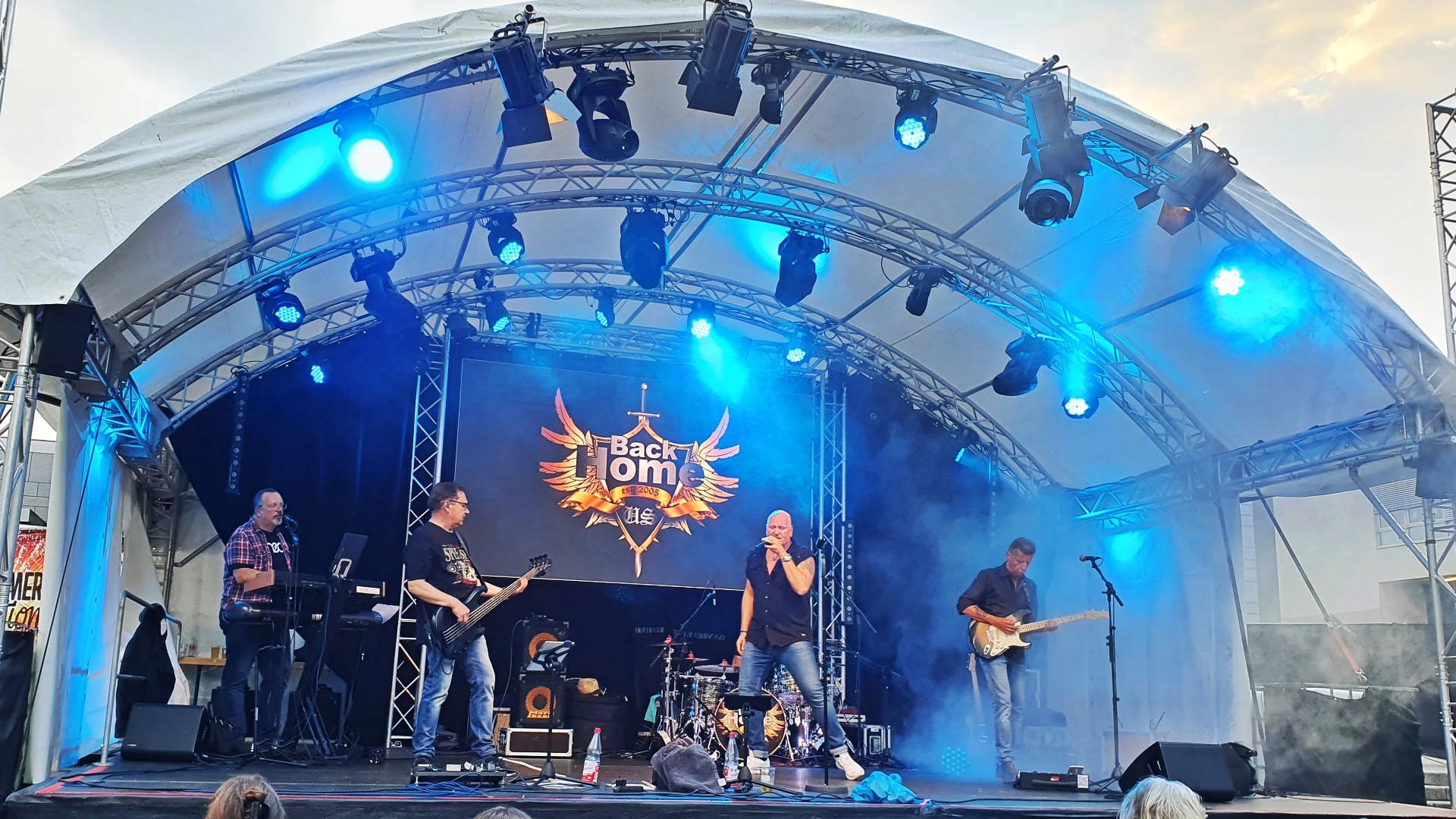 BackHome live auf der Bühne mit Banner